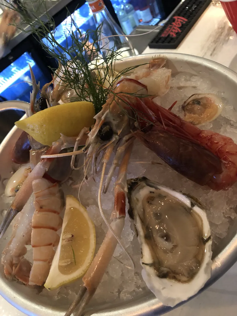 A raw seafood platter with oysters, scampi and prawns on ice